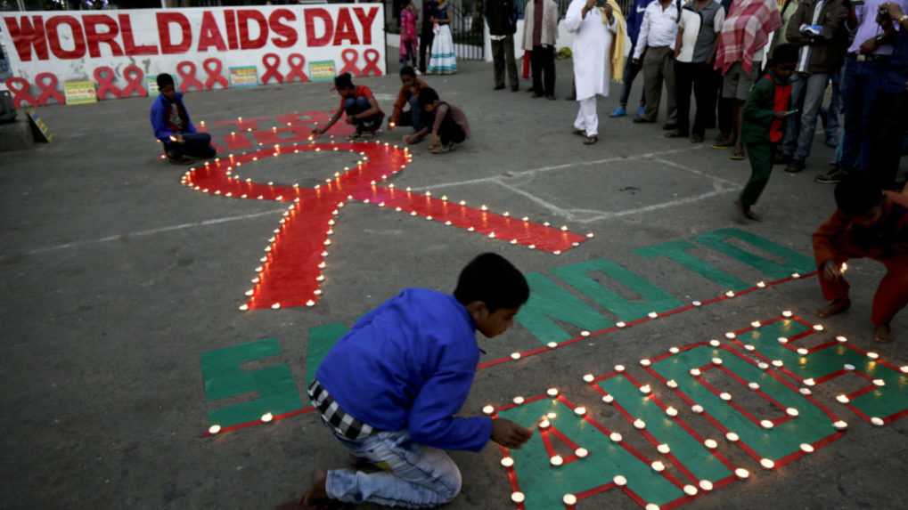 Zapaľovanie sviečok do tvaru červenej stužky pri príležitosti Svetového dňa boja proti AIDS v roku 2017 v Kalkate.