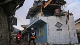 Na snímke muž kráča okolo zničeného domu po zemetrasení v indonézskom meste Cianjur.