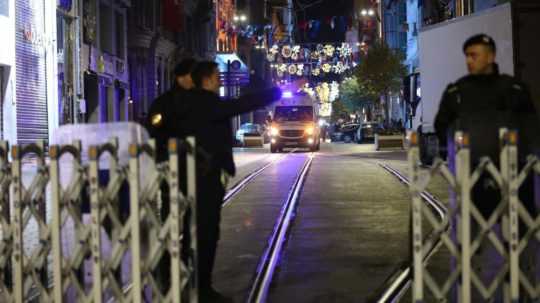 Policajti stoja pri vchode na ulicu, na ktorej došlo v nedeľu (13. 11.) k výbuchu.