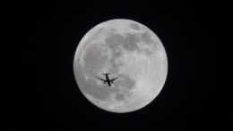 Na snímke silueta lietadla pred splnom Mesiaca.