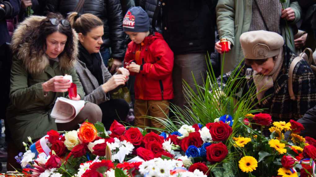 Na snímke ľudia prinášajú kvety a zapaľujú sviečky pri pamätníku Nežnej revolúcie na Národnej ulici v Prahe.