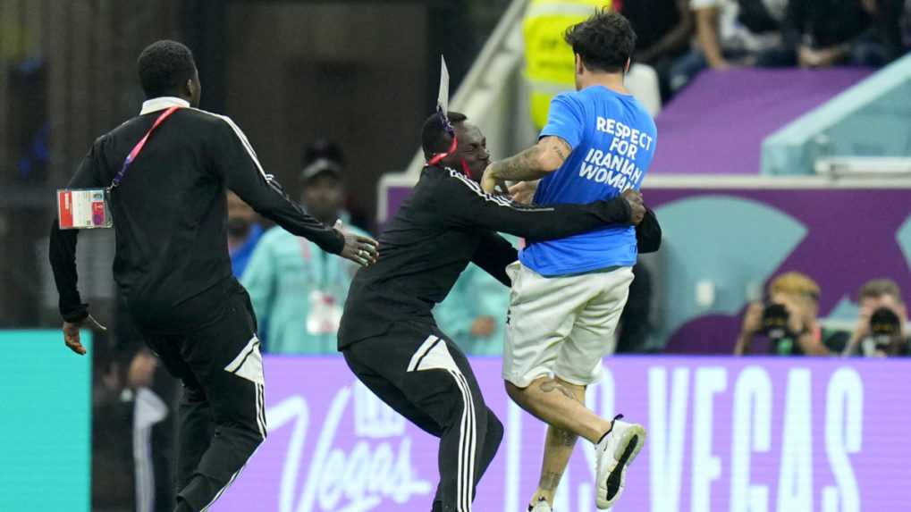 Na snímke sa príslušníci bezpečnostných zložiek snažia chytiť demonštranta s dúhovou vlajkou, ktorý vbehol na ihrisko počas zápasu Portugalska proti Uruguaju.