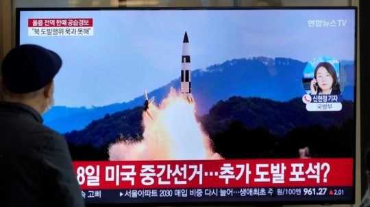 Ľudia v televízii sledujú na televíznej obrazovke archívne zábery vypálenia rakety Severnou Kóreou.