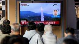 Na snímke ľudia sledujú televízne spravodajstvo s odpalom severokórejskej balistickej strely na archívnom zábere v Soule 3. novembra 2022.