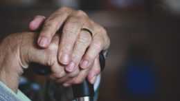 Na ilustračnej snímke dôchodca drží vychádzková palica.