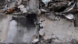 Na snímke dielo umelca Banksyho na budove zničenej ruským ostreľovaním.