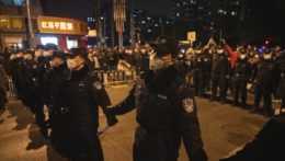 Čínski policajti vytvorili reťaz proti protestujúcim.