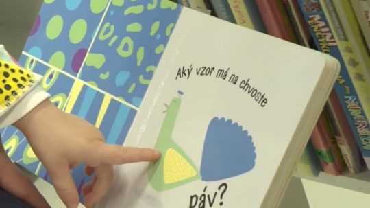 Na snímke dievčatko ukazuje na obrázok v detskej knižke.