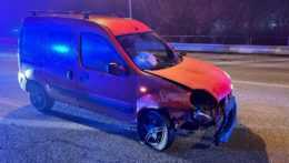 Na snímke je červené vozidlo značky Renault s rozbitým predným pravým svetlom a poškodenou prednou nápravou.