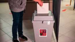 žena vhadzuje hlas do volebnej urny