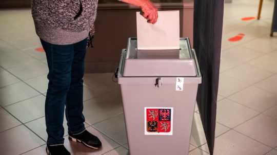 žena vhadzuje hlas do volebnej urny