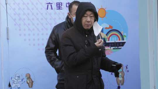 Na snímke si muž sníma respirátor pred testovaním na prítomnosť vírusu COVID-19 v čínskom Pekingu.