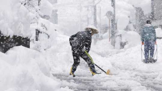 Obyvatelia odhŕňajú sneh počas hustého sneženia v japonskom meste Nagaoka.