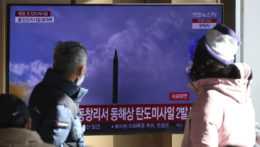 Na archívnej snímke ľudia sledujú vystrelenie balistickej rakety Severnou Kóreou.