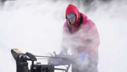 Muž odstraňuje sneh z klziska v centre meste Des Moines, americkom štáte Iowa.