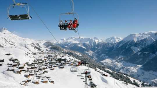 lyžiari na lanovke v rakúskych Alpách