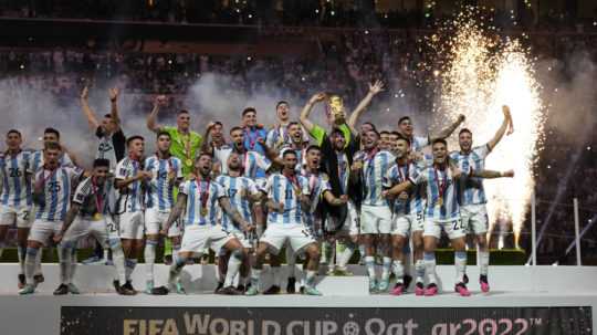 Argentínski futbalisti pózujú s trofejou po výhre vo finálovom zápase Argentína - Francúzsko na MS vo futbale v katarskom meste Lúsajl.