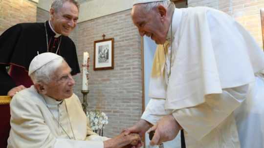 Na archívnej snímke pápež František podáva ruku emeritnému pápežovi Benediktovi XVI.