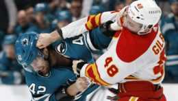 Jonah Gadjovich zo San Jose Sharks počas bitky s Dennisom Gilbertom z Calgary Flames.