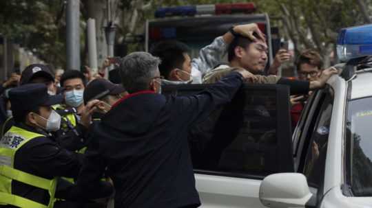 Čínska polícia zatýka jedného z demonštrantov.