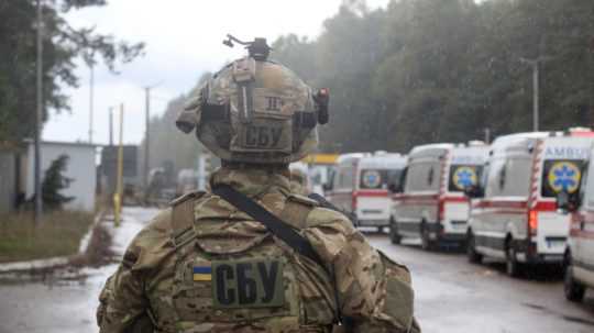 Na snímke je muž v maskáčovej uniforme a helme držiaci zbraň. Na chrbte má skratku Bezpečnostnej služby Ukrajiny.