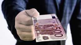 Muž podáva 500-eurové bankovky.