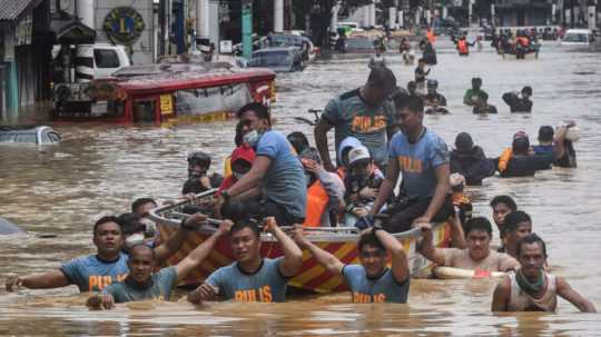 Príslušníci polície pomáhajú pri záchranárskych prácach počas záplav.