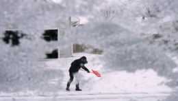 Miestny obyvateľ odhrabáva sneh z príjazdovej cesty v meste Urbandale, americkom štáte Iowa.
