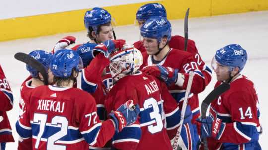 Slovenský hokejista Montrealu Canadiens Juraj Slafkovský (druhý sprava) sa teší so spoluhráčmi po výhre v zápase zámorskej hokejovej NHL Montreal Canadiens - Calgary Flames.