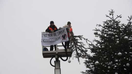 Klimatické aktivistky odpílili vrchol vianočného stromčeka umiestneného pred ikonickou Brandenburskou bránou v Berlíne.