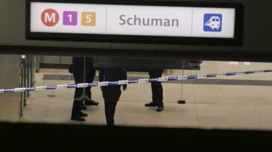 Policajt stojí pred policajnou páskou po útoku nožom na stanici metra Schuman.