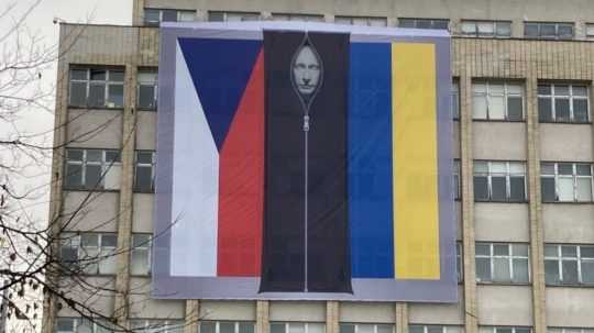 Medzi českou a ukrajinskou vlajkou je podobizeň ruského prezidenta Vlatimira Putina vo vaku na mŕtvoly na budove českého ministerstva vnútra v Prahe.