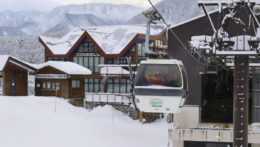 Policajti v kabínke smerujú na mieste pádu lavíny v lyžiarskom stredisku v dedine Otari v japonskej provincii Nagano.