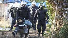 Policajti odpratávajú klimatického aktivistu na fúriku z nemeckého Lützerathu.