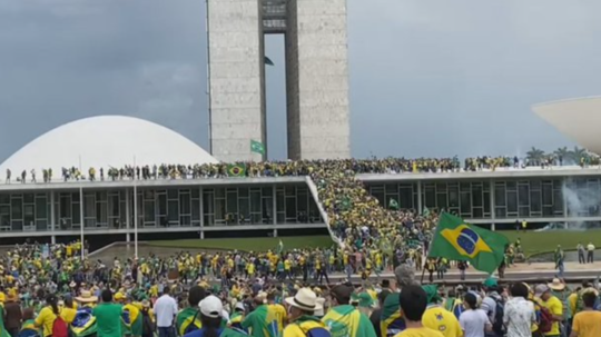 Na snímke z videa vidno obrovský dav ľudí, ktorí sa ženú do budovy parlamentu.