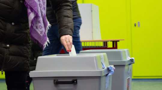 Žena vhadzuje hlasovací lístok do urny počas prezidentských volieb v Česku.