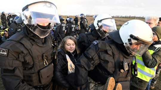 Policajti vynášajú švédsku klimatickú aktivistku Gretu Thunbergovú z demolačnej zóny počas protestnej akcie klimatických aktivistov deň po ich vysťahovaní z tábora v dedine Lützerath pri nemeckom meste Erkelenz.