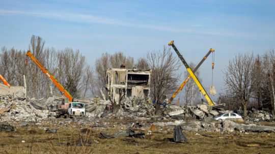 Robotníci odstraňujú ruiny po ukrajinskom raketovom útoku v Makijivke.