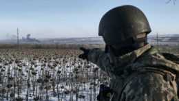 krajinský vojak ukazuje na dym počas bojov medzi ukrajinskou a ruskou armádou o mesto Soledar v Doneckej oblasti.