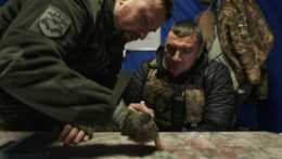 Ukrajinskí vojaci sa pozerajú na mapu v podzemnom veliteľskom centre vo východoukrajinskom meste Bachmut.