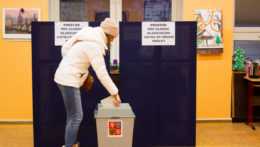 Na snímke volička vkladá obálku s hlasovacím lístkom do volebnej schránky v druhom kole českých prezidentských volieb vo volebnej miestnosti v Prahe.