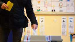 Na snímke volič vkladá obálku s hlasovacím lístkom do volebnej schránky v druhom kole českých prezidentských volieb vo volebnej miestnosti v Prahe v piatok 27. januára 2023.