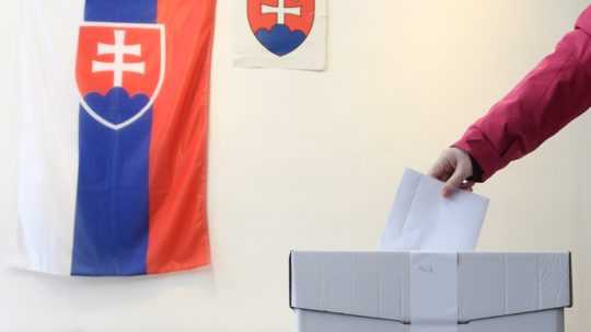 žena vhadzuje hlasovací lístok do volebnej urny