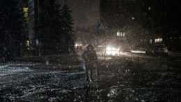 žena kráča tmavou ulicou v Kyjeve počas sneženia