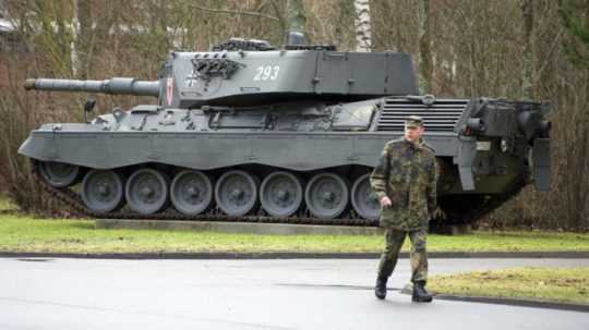 Na snímke prechádza vojak v blízkosti tanku typu Leopard 1.