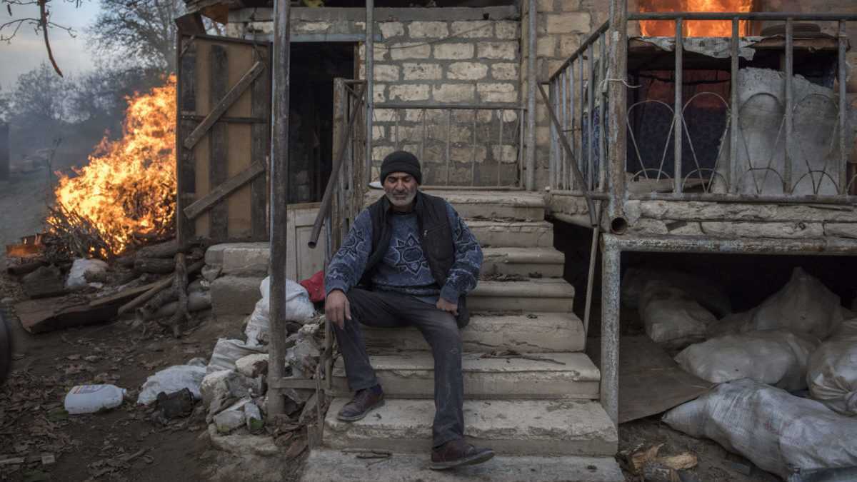 MuÃ…Â¾ sediaci pred horiacim domom v dedine v NÃƒÂ¡hornom Karabachu.