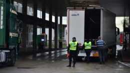 Českí policajti kontrolujú kamión na hraničnom priechode so Slovenskom.