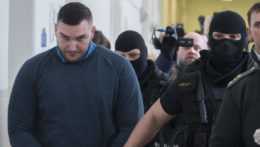 Policajti sprevádzajú Juraja Hossua do súdnej siene.