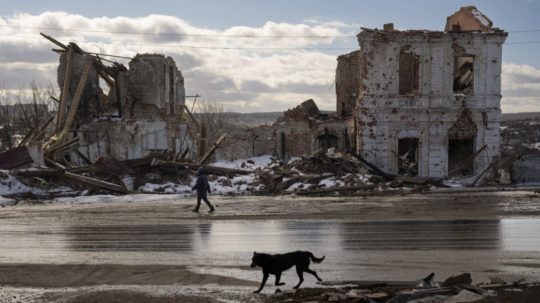 Žena kráča okolo budovy zničenej ruským útokom v ukrajinskom Kupiansku v pondelok 20. februára 2023.