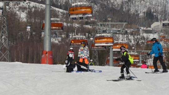 Na snímke, neďaleko vleku, leží zranený lyžiar. Okolo neho sa lyžujú návštevníci svahu.